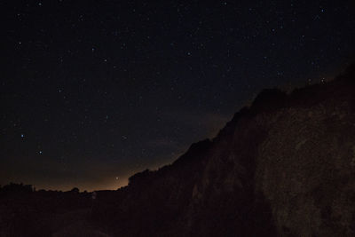 Low angle view of sunlight falling on mountain at night