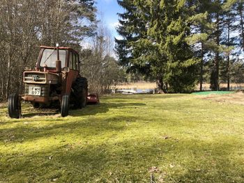 Tractor on field against trees