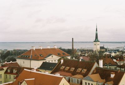 Aerial view of town by sea against sky