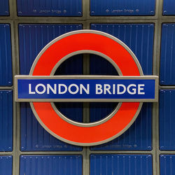 Close-up of road sign against blue sky