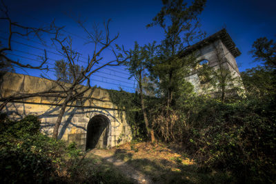 Low angle view of old ruin against clear blue sky