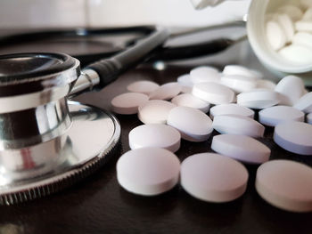 Close-up of stethoscope and pills on table