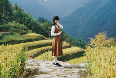 Full length of woman standing on mountain