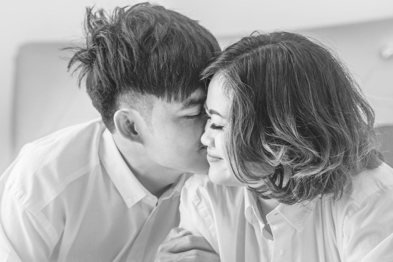 two people, love, togetherness, headshot, positive emotion, real people, bonding, men, emotion, young adult, young men, kissing, couple - relationship, adult, portrait, embracing, lifestyles, indoors, women, males, hairstyle