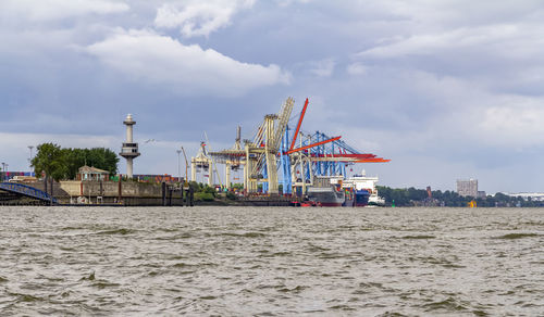 Commercial dock by sea against sky