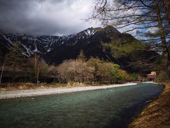 Scenic view of river against cloudy sky