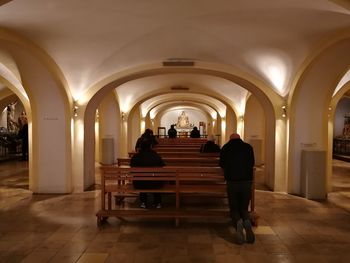 Rear view of people sitting in corridor