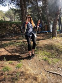 Full length of woman standing on tree trunk