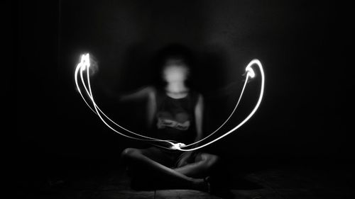 Close-up of woman using smart phone against black background