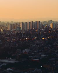 Illuminated cityscape against clear sky during sunset