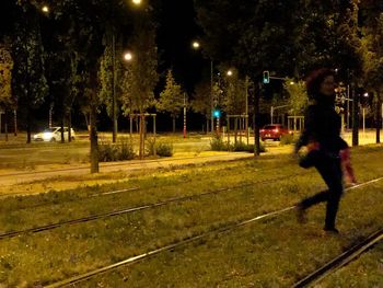 Side view of man walking on street at night