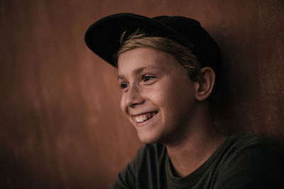 Portrait of smiling young man against wall
