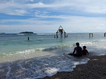 People at beach against sky