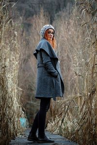 Full length portrait of woman standing in forest