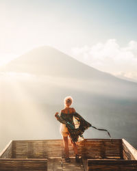 Full length of young woman on pier against sky