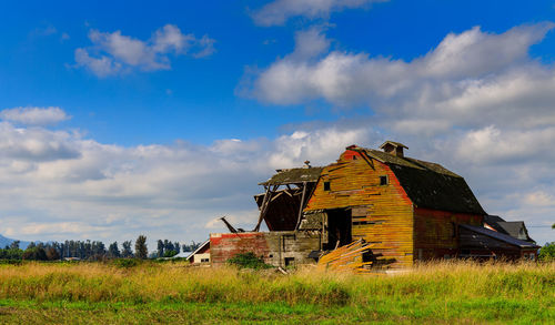Abandoned house on field against sky