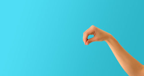 Close-up of hand against blue background