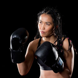 Portrait of beautiful young woman against black background