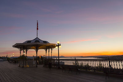Pier over sea against sky at sunset