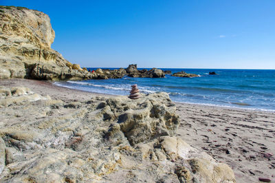 Scenic view of beach against clear blue sky