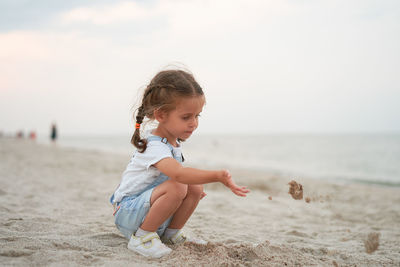 Cute boy on beach against sky
