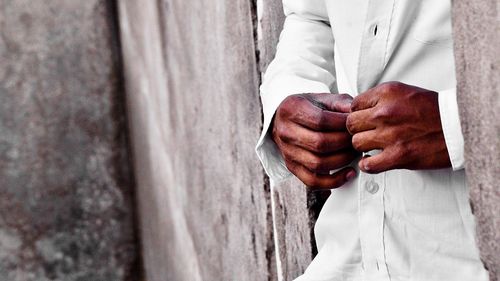 Close-up of man buttoning shirt