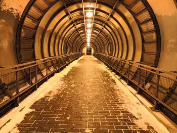 Empty footpath in illuminated tunnel