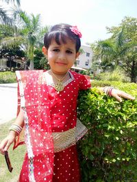 Portrait of smiling girl standing against plants