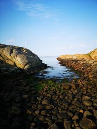 Rocks on sea shore against sky