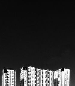 Modern buildings against clear sky at night