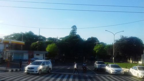 Cars on statue in city against clear sky