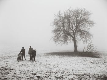 People walking on snow covered landscape