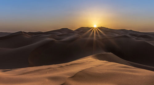 Scenic view of desert against sky during sunset