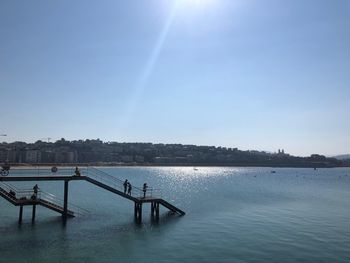 Pier over lake against blue sky