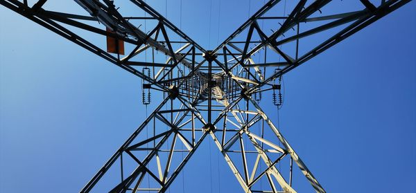 Low angle view of electricity pylon against clear sky