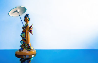 Low angle view of trophy against blue background