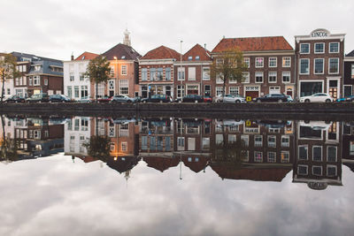 Reflection of houses in town against sky
