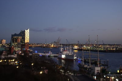 Illuminated harbor against sky at night