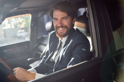 Portrait of a smiling young man sitting in car