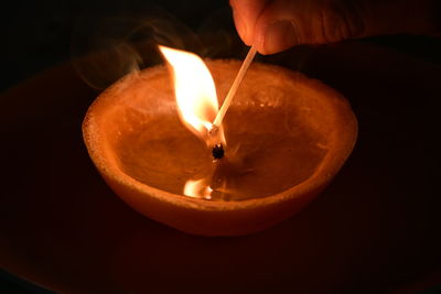 Close-up of hand holding burning candle