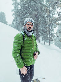 Portrait of woman standing on snow covered land