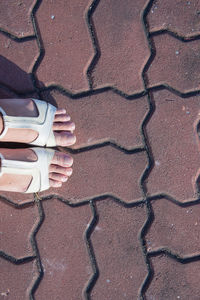 Low section of woman standing on footpath