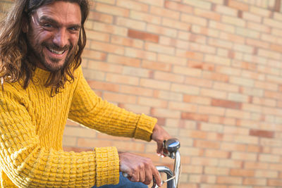 Portrait of smiling man against wall