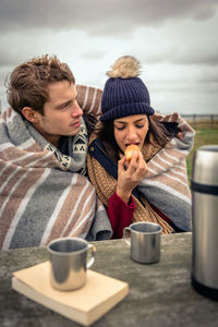 Young couple sitting on table outdoors