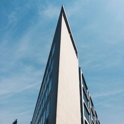 Low angle view of modern building against cloudy sky