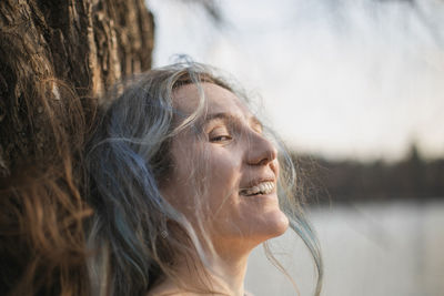 Close up woman with gray ruffled hair laughing and looking sideway portrait picture