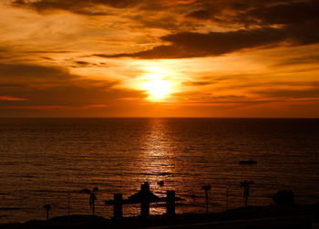 Silhouette people at beach against sky during sunset