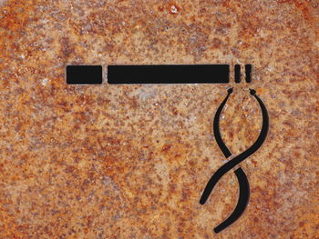 Close-up of smoking sign on rusty metal