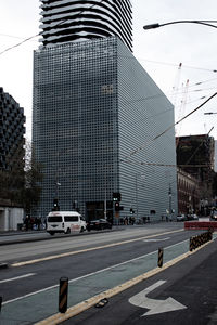 Traffic on road by buildings against sky