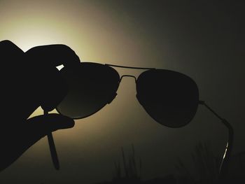 Low angle view of silhouette hand against sky during sunset